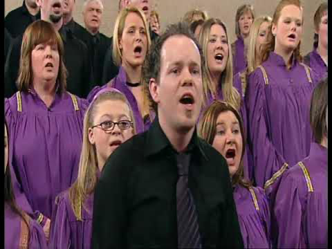 Mick, mid-solo, in front of a choir in purple robes